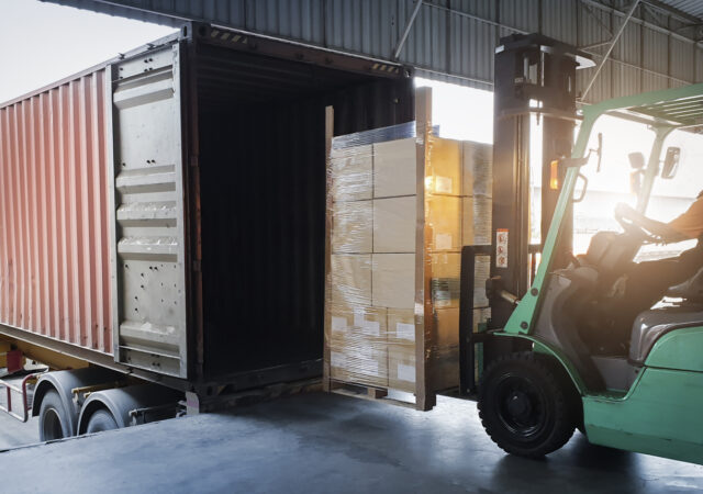 Forklift moving boxes into a truck